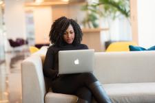 Woman sitting on couch staring at laptop screen